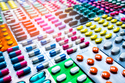 colorful tablets and capsules pill in blister packaging arranged with beautiful pattern with flare light