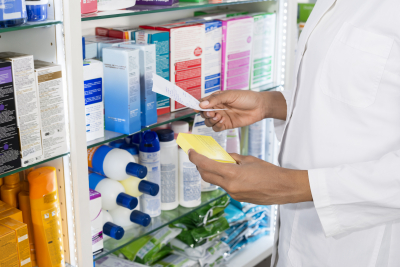 pharmacist holding receipt and prescription in pharmacy